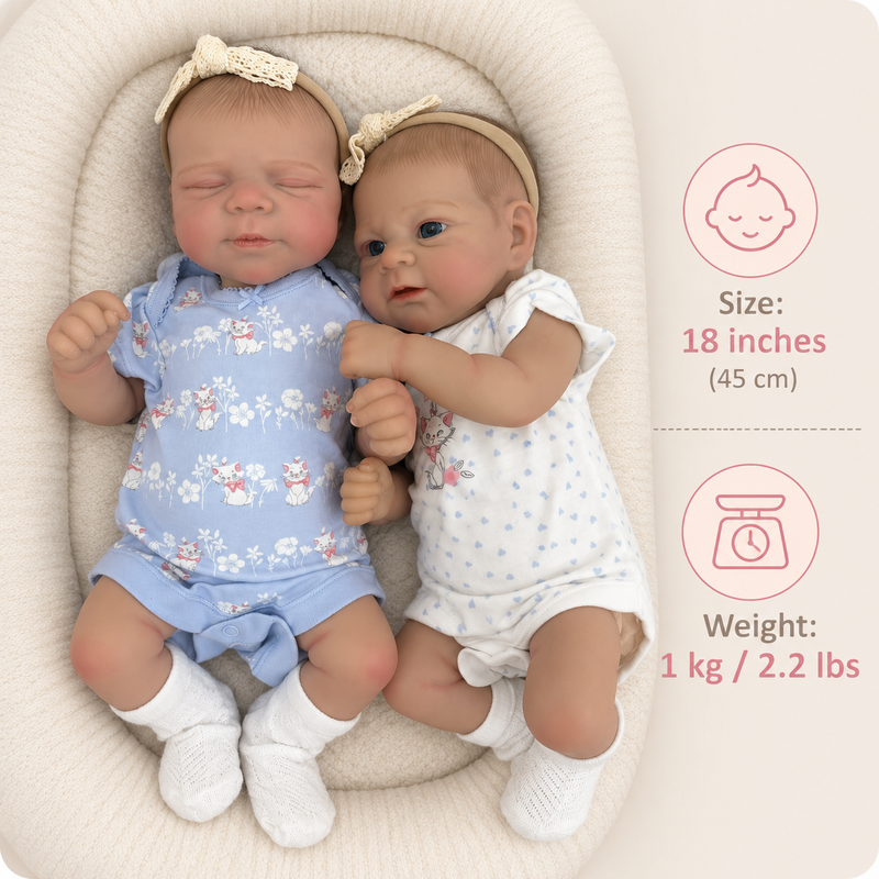 Two realistic reborn baby dolls lying side by side in a cream-colored bassinet. The doll on the left wears a light blue floral onesie, white socks, and a cream bow headband.