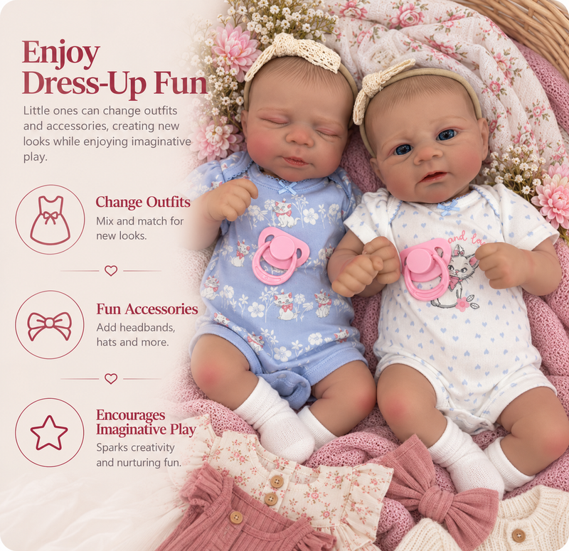 Two realistic baby dolls lying on a pink floral blanket, wearing matching outfits and accessories. One doll wears a light blue floral onesie with a pink pacifier and cream headband, and the other wears a white floral onesie with a pink pacifier and cream headband.