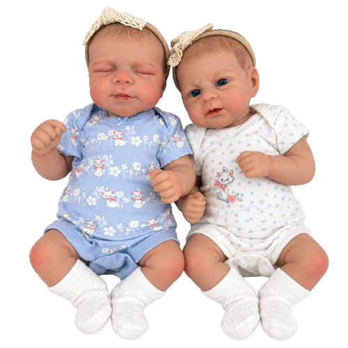 Two realistic baby dolls posed side by side on a plain white background. One doll wears a light blue onesie with a white bunny and flower print, a beige lace headband, and white socks.
